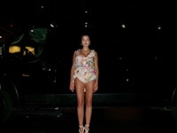 a woman is standing in front of a black van