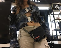 a woman wearing a chanel denim jacket and fanny pack