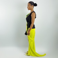 a woman in a yellow and black dress standing in front of a white background