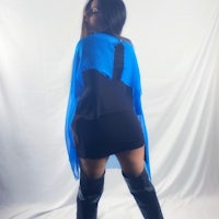 a woman wearing a blue cape and thigh high boots