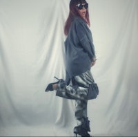 a woman posing in a gray camouflage jacket and pants