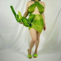 a woman in a green dress posing for a photo