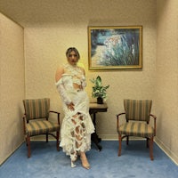 a woman in a white dress standing in a room