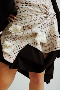 a woman wearing a black and white plaid skirt