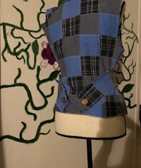 a blue and black patchwork vest on a mannequin