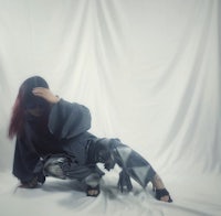 a woman is posing in front of a white background