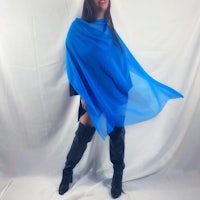 a woman in a blue poncho posing for a photo