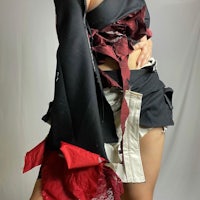 a woman is posing in a black and red outfit