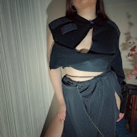 a woman is posing for a photo in a black skirt