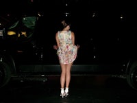 a woman is standing in front of a black van