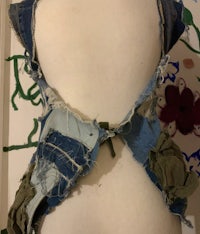 the back of a mannequin with a denim vest on it