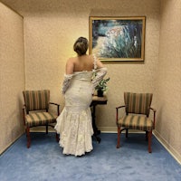 a woman in a wedding dress standing in a room