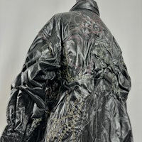 a black leather jacket with embroidery on it