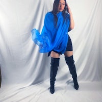 a woman wearing a blue shawl and thigh high boots