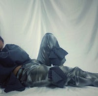 a woman laying on a bed in a black outfit