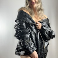 a woman posing in a black leather jacket