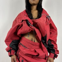 a woman in a red jacket and black skirt