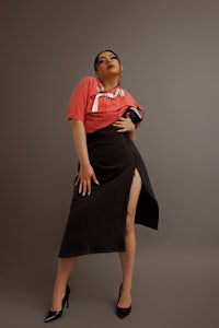 a woman in a black skirt posing for a photo