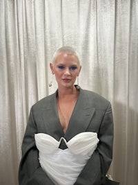 a woman in a grey suit and dress posing for a photo