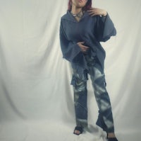 a woman is posing in front of a white background