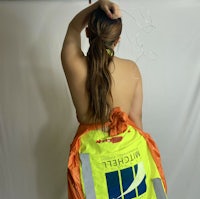 a woman in a safety vest with her back to the camera