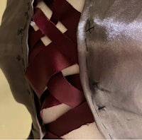 a mannequin with a burgundy ribbon on it