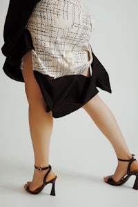 a woman in a black and white skirt and heels