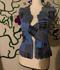 a mannequin wearing a blue and black vest