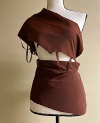 a brown one shoulder dress on a mannequin mannequin