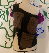 a mannequin wearing a black and brown top with pockets