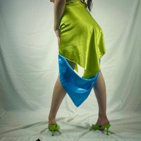 a woman posing in a green and blue skirt