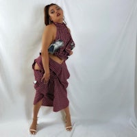 a woman posing in a burgundy and white checkered skirt