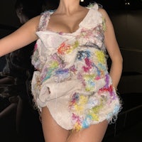 a woman is posing in a colorful dress